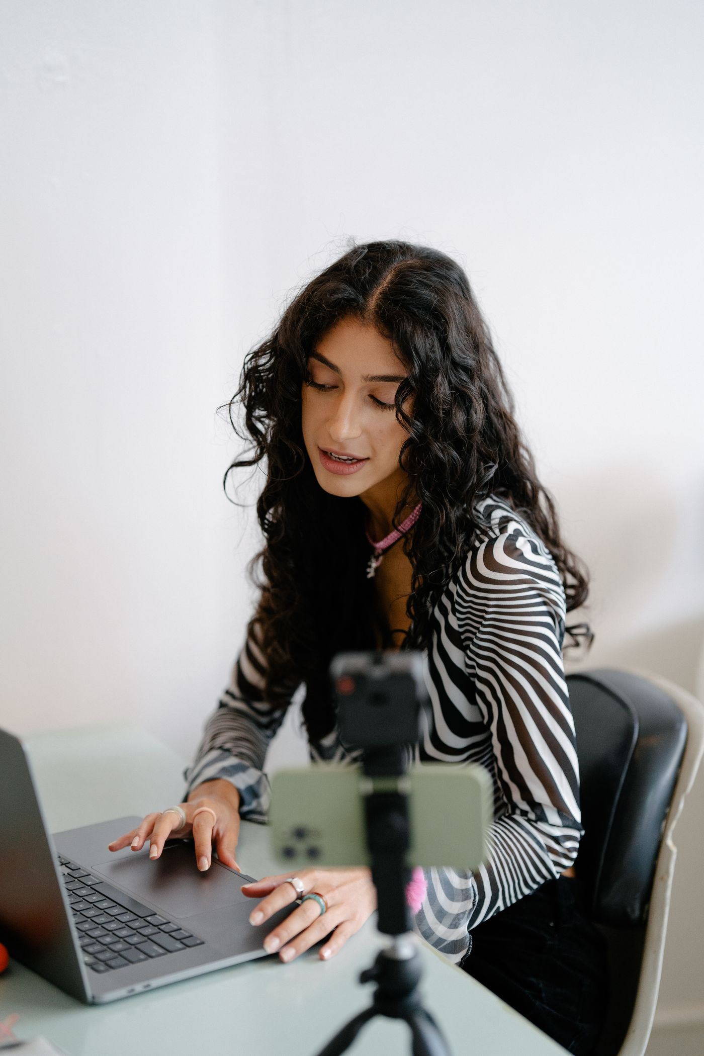 Creator producing lifestyle content with phone and laptop